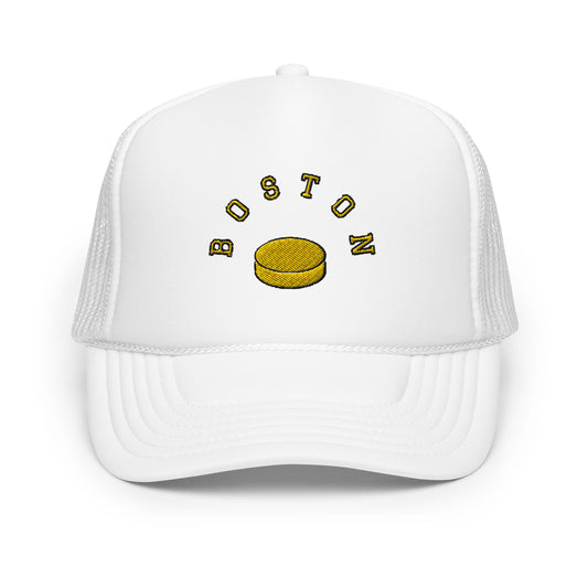 White hat-Text "Boston" in yellow with image of hockey puck